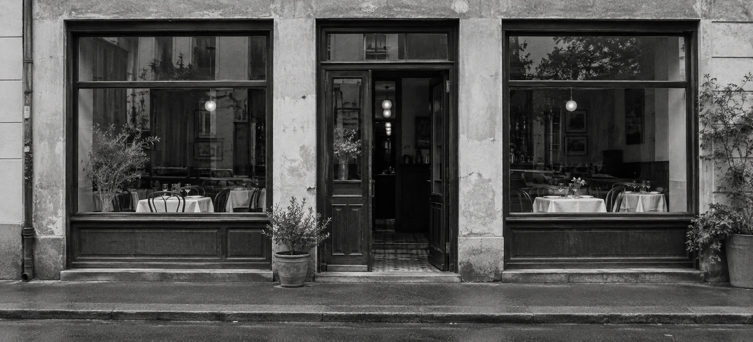 Fiktive Bistro-Location — frontal fotografierte Fassade in Schwarzweiß